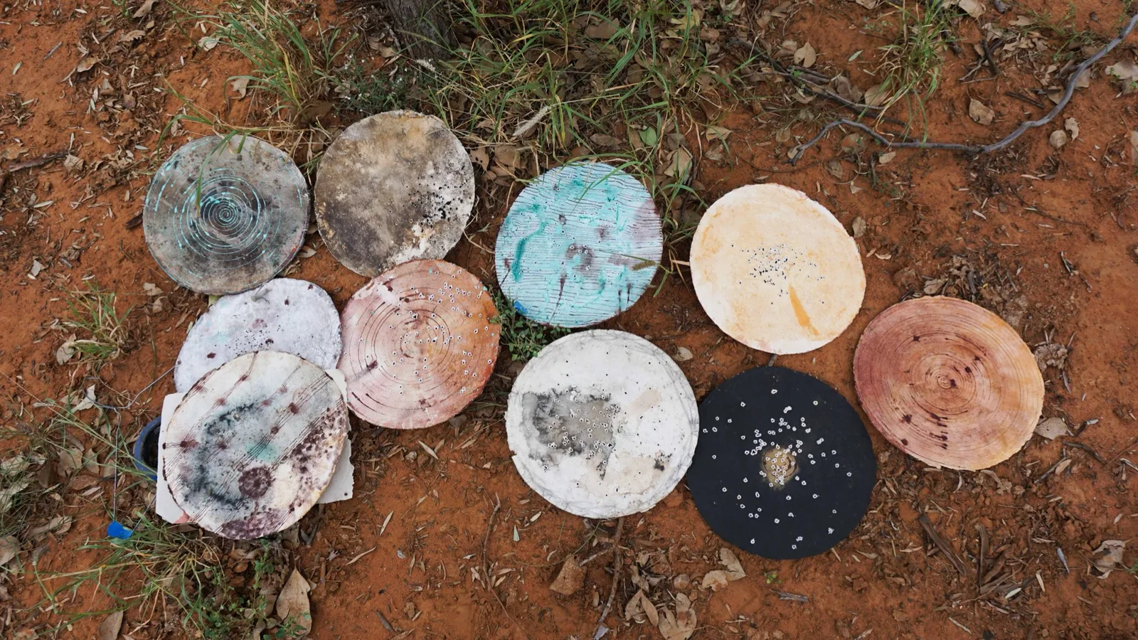 Circular works laid on red earth, outLAND, Alexandra Lawson Gallery