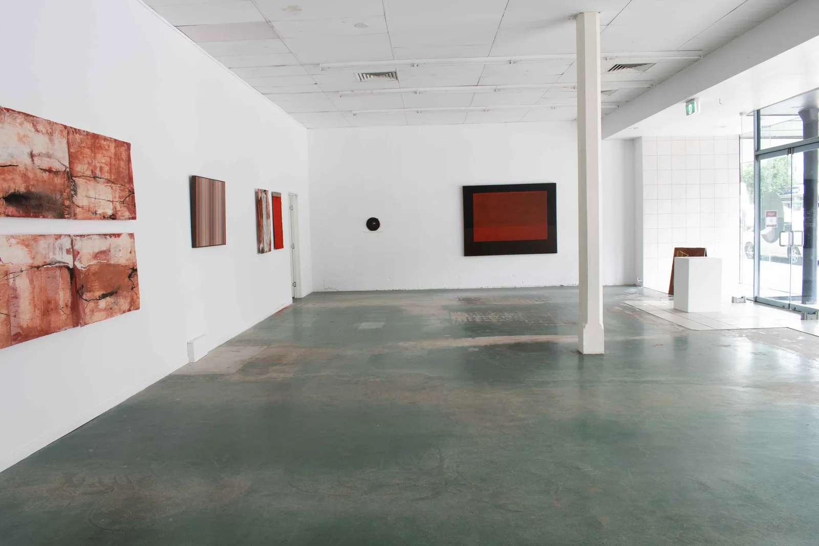 (Tarn McLean work on wall beside circular artist book)